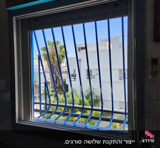 סורגים כחולים עם בטן מותקנים על חלון בית